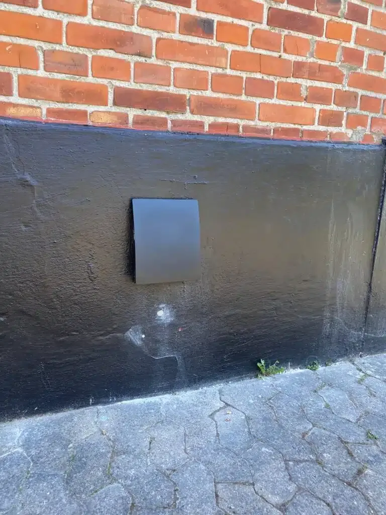 Mørk udvendig rist i sokkel